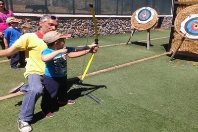 The instructor teaches the boy to get a bow exactly to the target. 