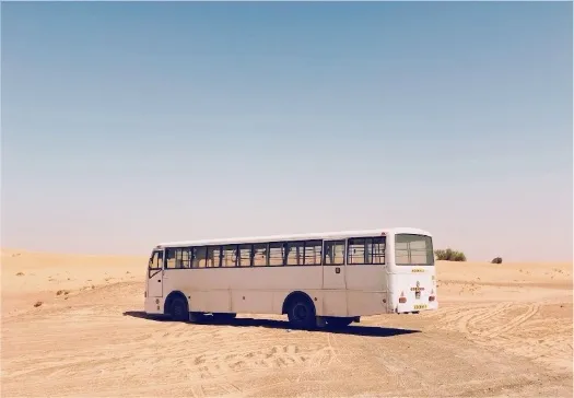 The bus is in the middle of the desert